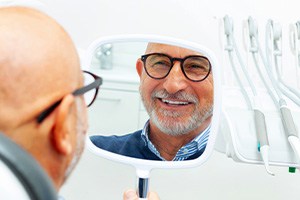 Patient with black glasses smiling at reflection