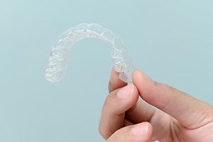 Closeup of patient holding clear aligner
