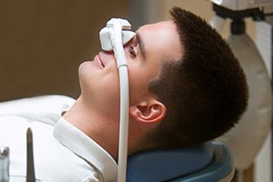 Patient relaxing while breathing in nitrous oxide in treatment chair
