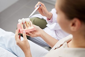 dentist showing a patient how dental implants work in Gainesville 