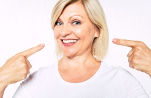 Woman smiling and pointing at her smile