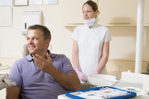 Man in dental chair talking to dentist