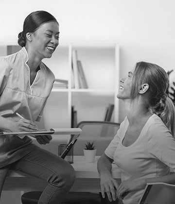 Two smiling women in dental office
