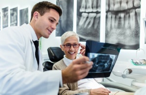 A dentist showing a patient an X-ray.