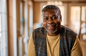 Closeup of man in plaid vest smiling at home