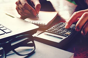 Woman calculating cost of dentures in Gainesville