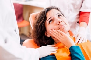 Woman with toothache visiting her Gainesville emergency dentist