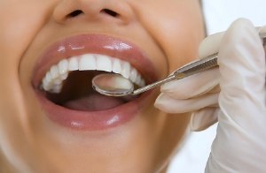 woman’s smile and dental mirror