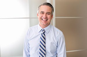 older man in tie smiling