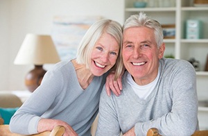 elderly couple in gray sweaters smiling