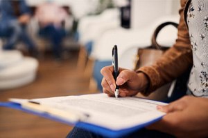 Closeup of patient filling out dental insurance forms 