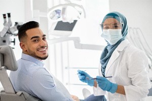 Patient smiling next to dentist in dental office 