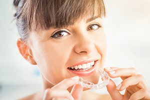 Woman placing Invisalign tray
