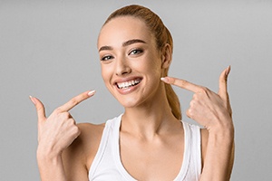 Woman pointing to her smile