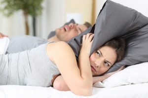 woman annoyed by man's snoring