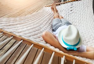 Man sleeping in hammock during summer after visiting his Gainesville dentist