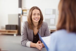 smiling woman in job interview after getting cosmetic dentistry in Gainesville 