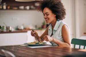 Woman with TMJ disorder eating pasta